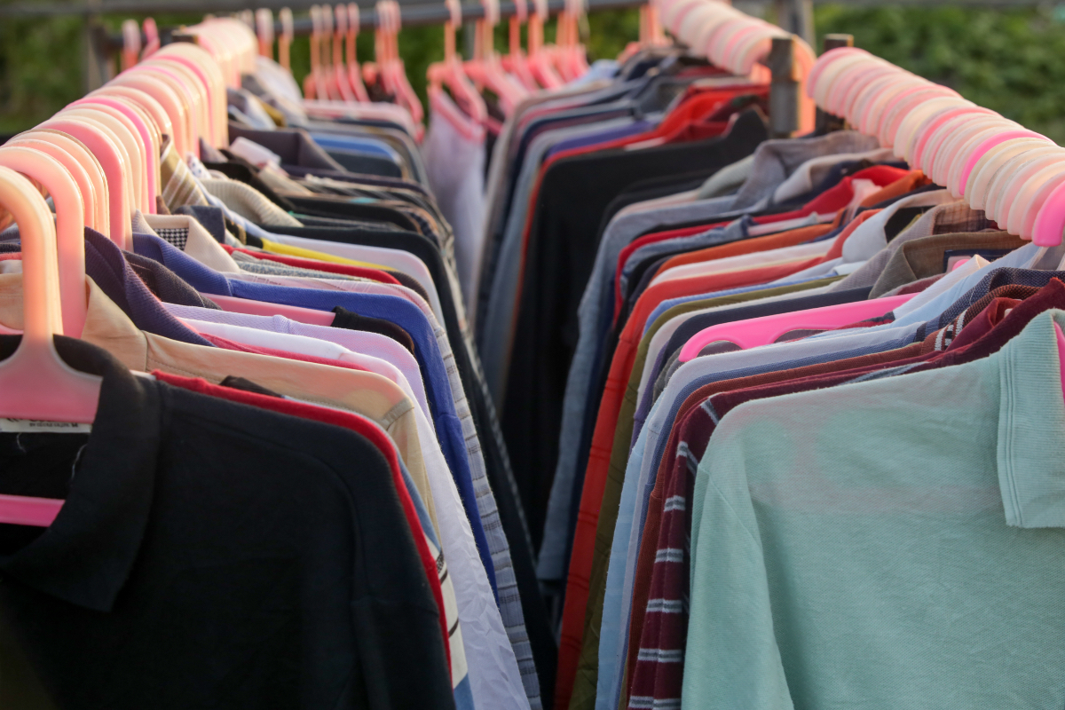Hemden und Shirts auf Kleiderbügeln in einem Kleidergeschäft.