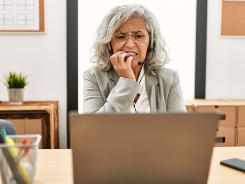 Eine ältere Angestellte schaut besorgt auf ihren Rechner.