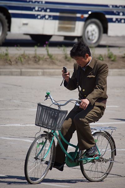 Nordkoreaner auf Fahrrad mit Handy.