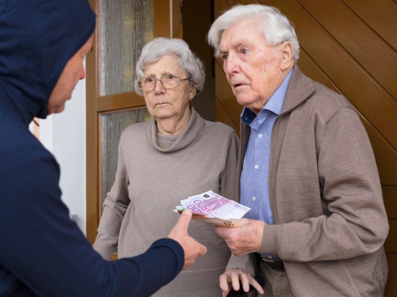 Zwei Rentner geben einem Enkeltrick-Betrüger Geld an der Haustür.