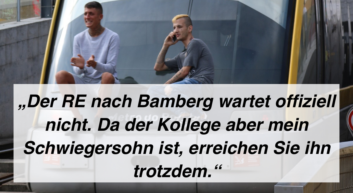 Zwei junge Männer sitzen auf dem Fenster eines Zuges.